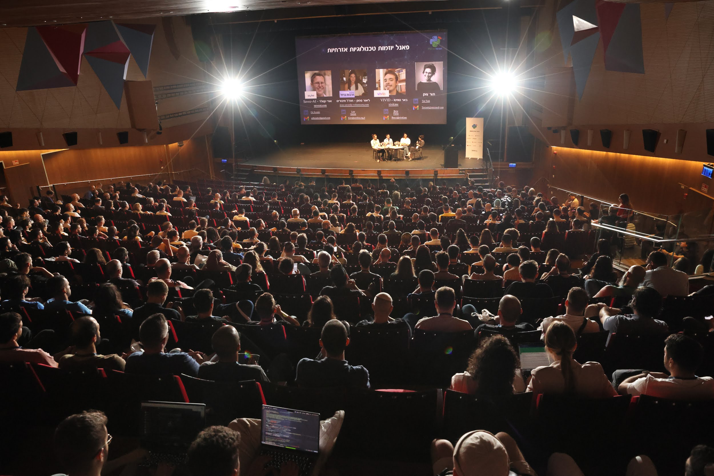 Image of 2024 hall with audience and panel slide on screen